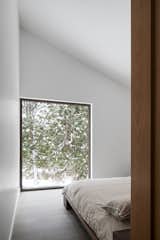 Set back from the main living areas, the master bedroom provides peaceful views of the cedars outside.