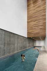 The indoor pool room pairs cool concrete with warm wood accents.