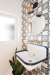 Cement tiles are featured in the bathroom, powder room, and even around the fireplace in this house in LA. The Teselle tile on the wall behind the sink make it a focal point of the small space.