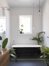 Potted plants add a sense of calm to the minimalist bathroom.