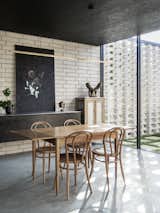 A Nathan Grey painting carries the dark motif of the kitchen into the dining space.