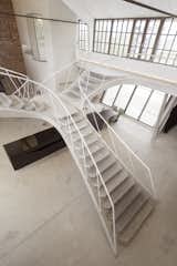The staircase branches out to hug both sides of the loft's upper walls.