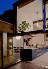 Large, pivoting glass doors connect the kitchen with a patio.