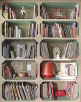 "The shelves with green-painted interiors—a nod to the cases found in old bookshelves—house the artist’s collection of comics, vinyl records, and objects," says Semerene.