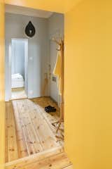 The entrance to the apartment is also painted a cheerful yellow.