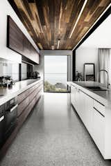 Concrete countertops by Newform Concreting lead the eye towards a large picture window.