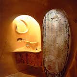 The bathroom features a sculptural sink and shower.