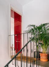 The entrance to the apartment offers a glimpse of glossy red cabinetry.