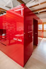 To reduce cost, Pardo constructed this glossy red volume using kitchen furniture units, so the clothing drawers are the same type used for cutlery in the kitchen nook, and the same sink model was used for both the kitchen and bathroom.