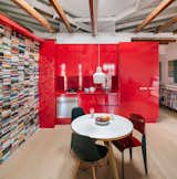 The red furniture system, which does not extend all the way up to the ceiling, works as a frame that structures the interiors. It contains the kitchen and bathroom, and  also provides ample storage for Rubio’s books, designer furniture, and decor.