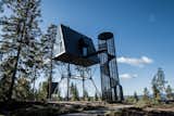 A spiral staircase, inspired by fire lookout towers, leads up to the A-frame cabin.