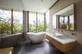 A freestanding tub, placed near a window, enjoys a green view as well as privacy.