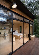 Located in a forested, countryside area near a lake and vegetable garden, the cabin was designed by São Paulo architect Silvia Acar as a simple space for sleeping, cooking, and reconnecting with nature.