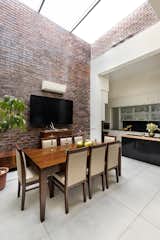 Dining Room, Table, Ceramic Tile Floor, Lamps, Wall Lighting, Brick Floor, Stools, Concrete Floor, and Track Lighting  Photo 11 of 26 in The Brick House by Studio Ardete