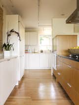 Kitchen, Engineered Quartz Counter, White Cabinet, Refrigerator, Wall Oven, Wood Cabinet, Medium Hardwood Floor, Ceiling Lighting, Dishwasher, and Drop In Sink Work aisle  Photos from Sonoma Modern Kitchen
