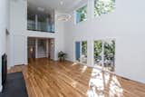 Living Room, Ceiling Lighting, Gas Burning Fireplace, Recessed Lighting, and Light Hardwood Floor Two Story Living Room with Glass Balcony Overlook and Slate Hearth  Photo 1 of 12 in Modern Urban Treehouse by Denika Jones Almburg