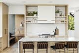 Kitchen, Refrigerator, Laminate Cabinet, Engineered Quartz Counter, Microwave, Medium Hardwood Floor, Wall Oven, Undermount Sink, Wine Cooler, Dishwasher, Ceiling Lighting, Track Lighting, and Cooktops  Photo 9 of 21 in Mississippi River Valley Residence by Sustainable 9 Design + Build