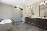 Bath Room, Engineered Quartz Counter, Accent Lighting, Ceiling Lighting, Freestanding Tub, Enclosed Shower, Ceramic Tile Floor, and Drop In Sink  Photo 14 of 23 in Bald Eagle Lake Residence by Sustainable 9 Design + Build