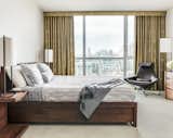 Bed, nightstands and dresser in walnut by DWR. Holly Hunt lights throughout. Metropolitan Lounge chair and ottoman by B&B Italia. Bentley carpet, wallcovering by Graham & Brown and drapery from Rodolph. Bedding and throw from Yves Delorme.