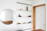 Opposite the sink, steel shelving adds storage with a minimal profile.