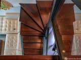 Custom recycled hand built spiral staircase, made from the bones of the existing aluminum straight stairs, covered in custom cut Mahogany wood.