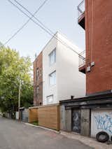 Exterior, Brick Siding Material, Flat RoofLine, and Apartment Building Type New white brick volume addition to the back alley landscape  Photo 8 of 20 in RJM apartment by Alexandre Bernier Architecte