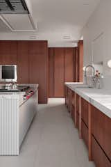 Kitchen, Wall Lighting, Refrigerator, Range, Wood Cabinet, Wall Oven, Porcelain Tile Floor, Undermount Sink, Marble Backsplashe, and Marble Counter Residence CEDAR- Kitchen  Photo 19 of 45 in Residence CEDAR by Alexandre Bernier Architecte