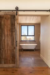 Main bathroom has a very warm feeling created by the raw elements used on the floors, walls and ceiling.