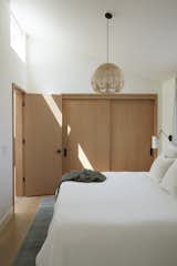 Bedroom, Pendant Lighting, and Bed One important aspect to our client was the ability to age in place. A bedroom on the lower level keeps everything accessible for those who need it.  Photo 13 of 16 in Millbrae House by Red Dot Studio