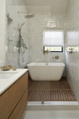 The primary bath features weathered white Zellige tile by Cle and a curbless shower.