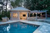 Built from western red cedar, this outdoor kitchen and pergola features V-groove siding set in a horizontal pattern.  A folding window is set into the building's front for easy access.