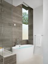 Master bathroom with marble tile and custom steel corner window.