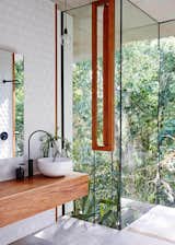 An open, glass-encased shower gives the homeowners the sensation of bathing outdoors.