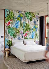 The wall in the master bedroom is upholstered in original fabric by Christian Lacroix.