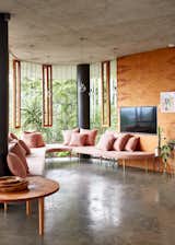 A curved pink couch designed by Campagnolo curves around a 1970s-style conversation pit in the living room.
