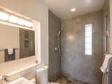 Renovated bathroom with custom cabinetry and hand poured concrete tiles.