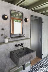 The new casita bathroom features a custom concrete sink, plaster walls, and custom concrete tile.