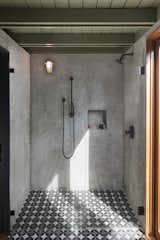 The concrete tile transitions into the plaster shower for a seamless look.