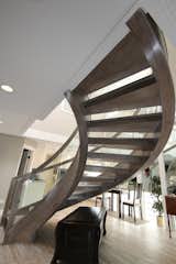 The open framing shows off the custom curved design of this handcrafted modern staircase.  