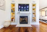 Custom cabinetry around custom limestone fireplace in sitting room off master bedroom where TV is viewed.