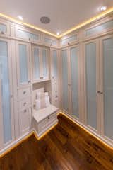 Master bedroom closet with custom cabinets, custom lighting features, and frosted glass panels to conceal the closet contents and keep everything dust free.