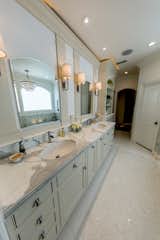 Master bath his and her sinks with tub chandelier reflecting in the mirror.