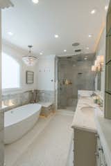 Master bath retreat with spa tub, steam shower, and his and her sinks. There is also a fireplace in the wall at the foot of the tub.