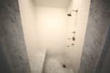 1920s inspired walk in shower with marble trim and seats. 