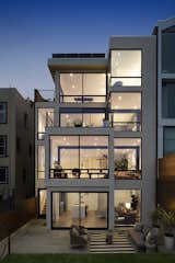 A modern silhouette and exposed steel beams frame backyard views. 