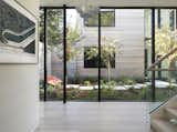 Four distinct wood-clad pavilions, connected by glazed walkways, surrounds a central courtyard. 