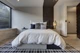 Another monochromatic bedroom with a peak at the signature wallpaper in the hallway.