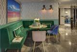Olga Hanono's signature wallpaper is juxtaposed by jewel tone seating and colorful artwork.
