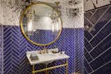 Powder room offers a playful twist on subway tile with a blue herringbone pattern.