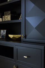 Custom 3D door panels with brass accents offer storage in the family room.